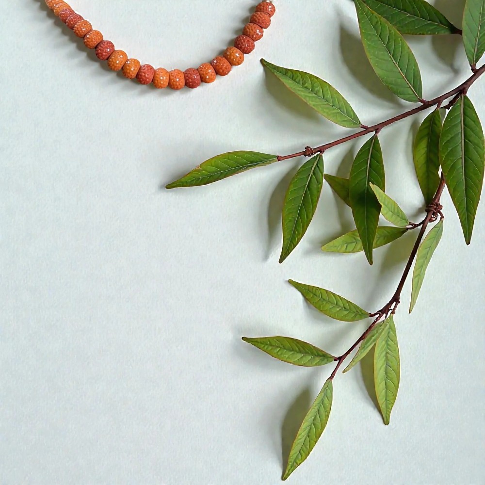 Naszyjnik z korali rudraksha w naturalnej kompozycji z liśćmi – styl lifestylele
