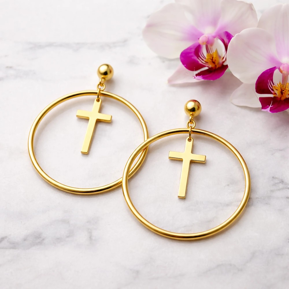 Kolczyki koła z krzyżykiem w kolorze złotym – flat lay na białym marmurze z różową orchideą