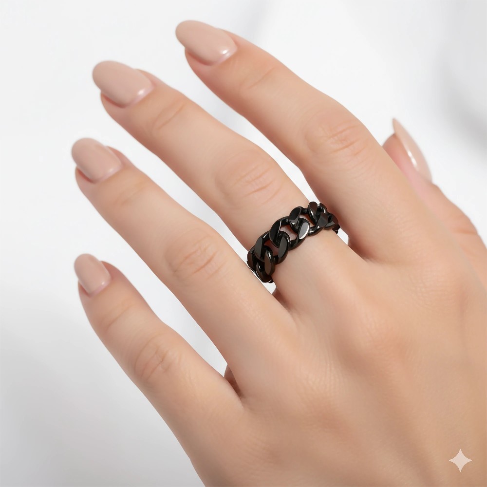 Modelka prezentująca czarną obrączkę pancerka na palcu serdecznym, widoczny kontrast z jasną karnacją i manicure..