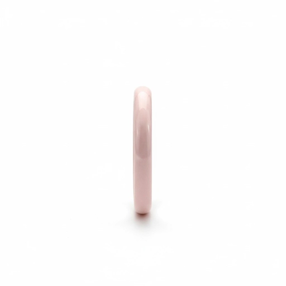 Bladoróżowa obrączka ceramiczna gładka o szerokości 0,3 cm, ujęcie na wprost na białym tle.