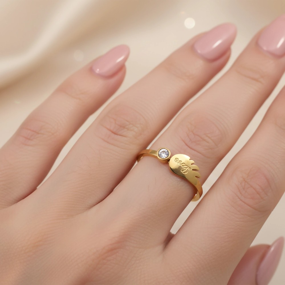 Delikatny pierścionek skrzydełko na dłoni z różowym manicure, stal chirurgiczna.